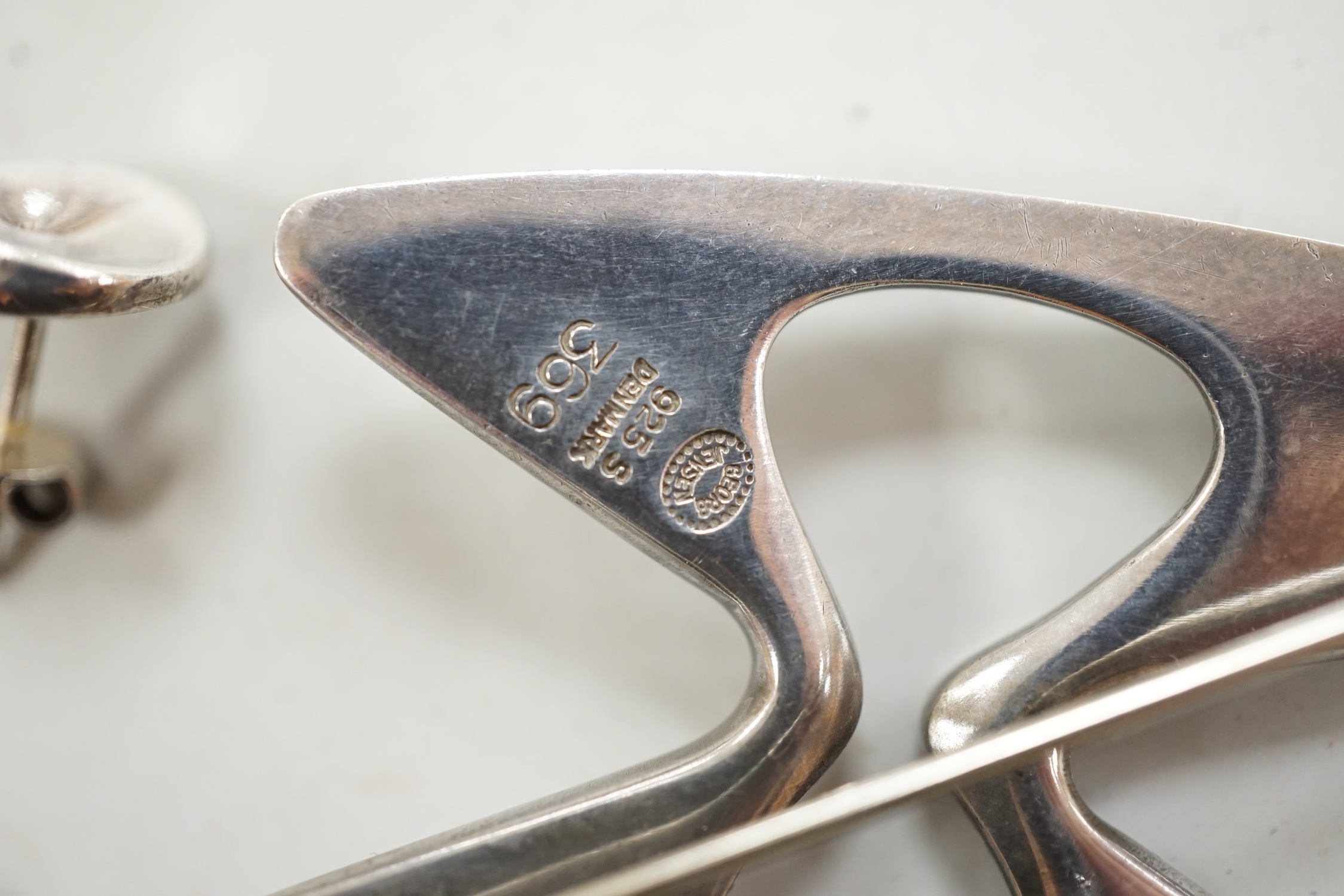 A Georg Jensen sterling free form brooch, design no. 369, a pair of Georg Jensen ear studs and two white metal rings.